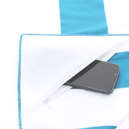 A blue and white striped towel features a zippered pocket, with a smartphone partially visible inside.