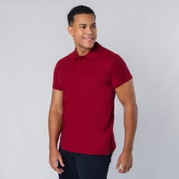A red polo shirt with a collar, short sleeves, and a side slit, worn by a smiling model. It features a logo.