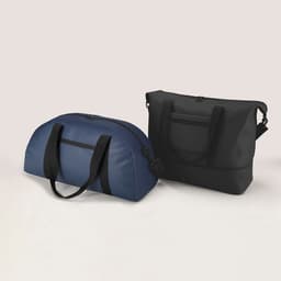 A blue duffle bag and a black shoulder bag, both featuring handles and zippers, side by side. Each bag has a logo.