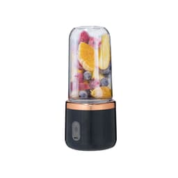 A black and copper blender with a clear container filled with various fruits, including oranges, berries, and bananas.