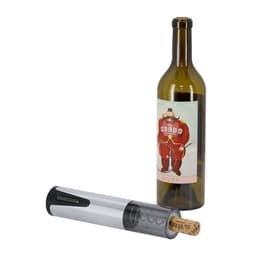 A silver electric corkscrew next to a green wine bottle with a cartoonish label. The cork is partially removed.