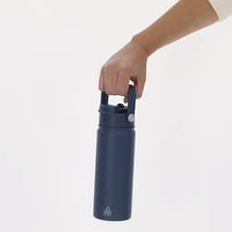A drink bottle in navy blue, held by a hand, featuring a handle and a logo on the front.