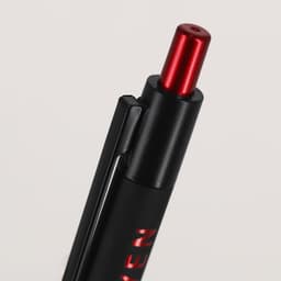 A metal pen featuring a black body and a red tip, with a branding logo visible.