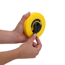 A tape measure in a bright yellow casing held by a hand, featuring a black retrieval mechanism.