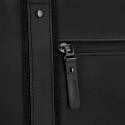 A close-up of a black velor bag featuring a zippered pocket and a stylish zipper pull.