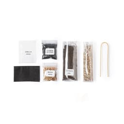 A collection of packaged seeds, soil, moss, and carbon biochar, with a wooden stick, all in clear bags.
