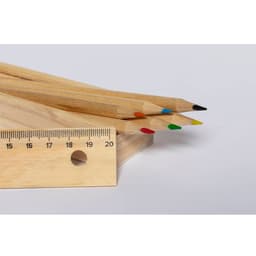 A set of grey-lead pencils in natural wooden casings with red, blue, green, yellow, and black tips beside a wooden ruler.