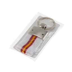 A keyring with a silver metal attachment and a white strap featuring red and yellow stripes, packaged in clear plastic.
