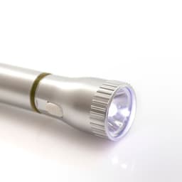 A silver pen torch with a round light at the end and a side button for activation. It has a sleek design and shine.