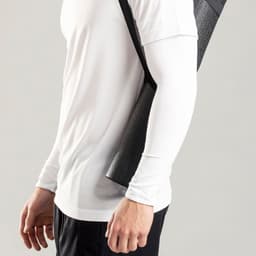 A person wearing a white long-sleeve shirt, carrying a black mesh tote bag over their shoulder.