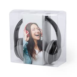 A pair of black and grey headphones are displayed in a clear packaging with a smiling woman wearing red headphones.