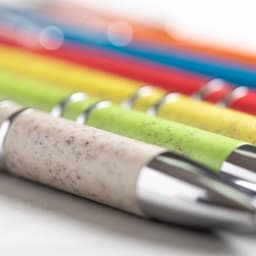 A row of colourful Nukot pens in various shades, featuring a blend of textured and smooth finishes with a silver trim.