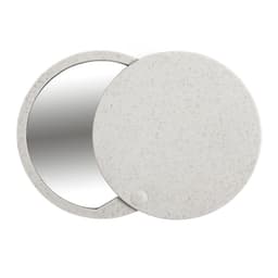 A round, compact mirror with a speckled white exterior and a reflective surface. It features a simple design and a small logo.