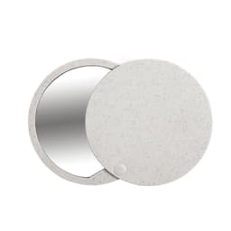 A circular mirror with a speckled white casing, featuring a smooth, reflective surface and a small button.