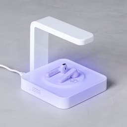 A wireless charger in white with a transparent stand, featuring space for earphones to charge.