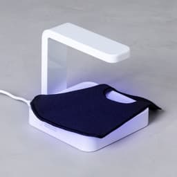 A wireless charger in white with a sleek design, featuring a light underneath and a black charging pad.