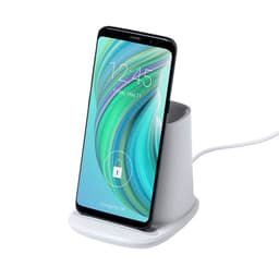 A white multifunction pencil holder with a smartphone docked, featuring a wireless charging pad.