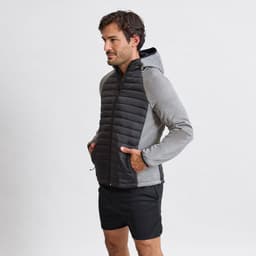 A soft shell jacket with a grey body and black quilted front, featuring a hood and pockets.