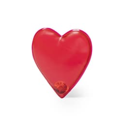 A heart-shaped heat pack in bright red, featuring a small circular component inside, with a branding logo.