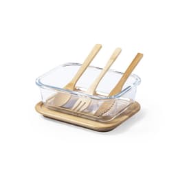 A glass lunch box with a wooden base, containing three wooden utensils: a spoon, fork, and knife.