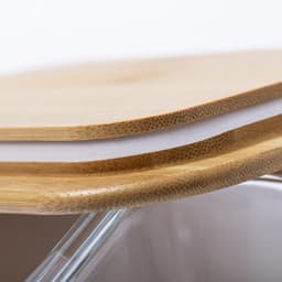A bamboo lunch box featuring a natural wood top and a transparent base, with a logo visible on the side.