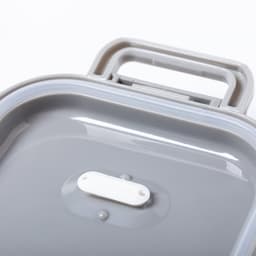 A grey thermal lunch box with a handle on top and a smooth, glossy interior surface. It features a small white label.