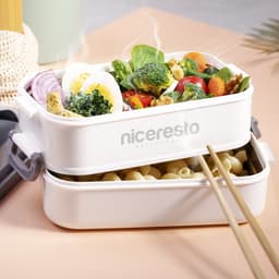 A white thermal lunch box containing pasta and a variety of vegetables, topped with a boiled egg.
