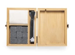 A bamboo box containing stone ice cubes, a cleaning cloth, and a stirring tool. The cubes are grey, and the box has a natural wood finish.