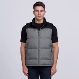 A man wearing a grey puffer vest with a black top. The vest features a zip and side pockets.