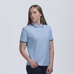 A light blue women's polo shirt with a collar, featuring contrast stripes on the sleeves and a logo.