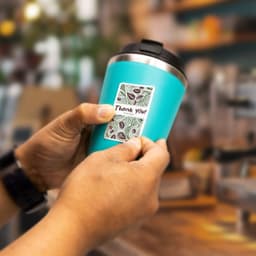 A turquoise drink bottle is held, featuring a decorative sticker with a pattern and the phrase "Thank You."