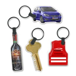 A collection of four key rings, including a car, a wine bottle, a key, and a red vest, all on black rings.