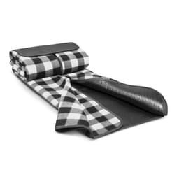A black and white checked picnic blanket, rolled up with a black leather strap and a waterproof backing.