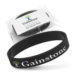 A black silicone wristband with debossed branding, presented in a clear package with a label.