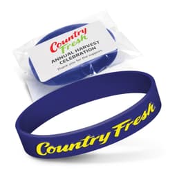 A blue silicone wristband is displayed in packaging with a logo. The band features embossed text.