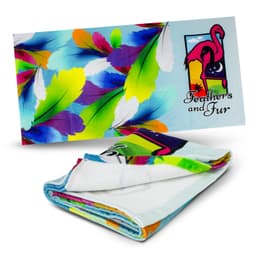A colourful beach towel featuring vibrant feathers and a flamingo design. It has a logo on one side.