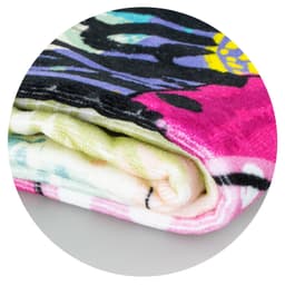 A rolled-up Picasso Beach Towel featuring vibrant colors and abstract patterns.