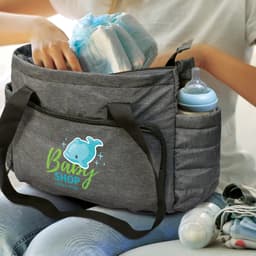 A grey baby bag with a logo, featuring compartments for bottles and diapers, being packed by a person.