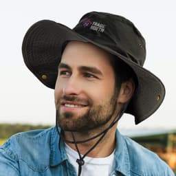 A black oilskin wide brim hat with a logo, featuring a drawstring and a textured brim, worn by a smiling man.