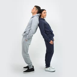 A unisex hoodie in grey and navy worn by two models, standing back to back, featuring a logo on the hood.
