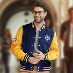 A navy and yellow custom varsity jacket with a logo and striped ribbing, worn by a smiling man.