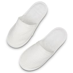 A pair of white waffle slippers with a textured surface and a soft, plush interior.