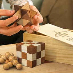 A wooden brain teaser set featuring various puzzles in natural wood tones, accompanied by a storage box.
