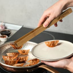 Bamboo serving tongs in a rectangular kraft paper box with a logo, featuring a natural wood finish.
