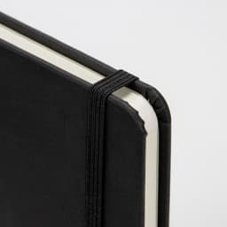 A5 weekly diary in black with a textured cover and elastic closure, featuring rounded corners.