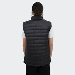 A women's puffer vest in black, featuring a high collar and a quilted design, worn over a white top.