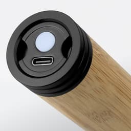 A bamboo torch featuring a USB-C charging port and a control button on the top. It has a sleek, natural wooden finish.