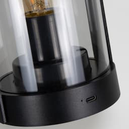 A black Keepsake Halo Lantern with a transparent glass enclosure and a visible light bulb inside.