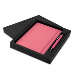 A pink notebook and matching pen presented in a black gift box. It features a sleek design with a logo.