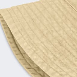 A beige bucket hat with a textured fabric and a wide brim, featuring a logo on the side.